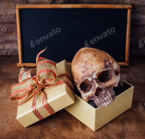 Preview: Model Skull In The Gift Box With Blackboard On Old Wooden Floor