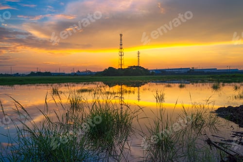 Preview: Telecommunications Towers Near The Secret Sky After The Sun'S Reflection In A Pond.