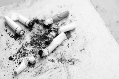 Preview: Cigarette Butts On Wood Background. Black And White Tone.