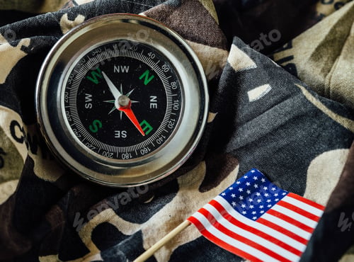 Preview: Old Magnetic Compass And Us Flag On A Camouflage Fabric Of War.