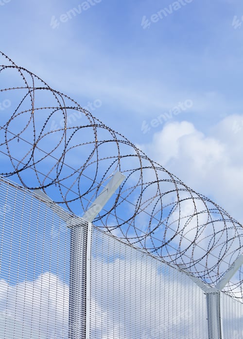 Preview: Chain Link Fence With Barbed Wire Under Blue Sky