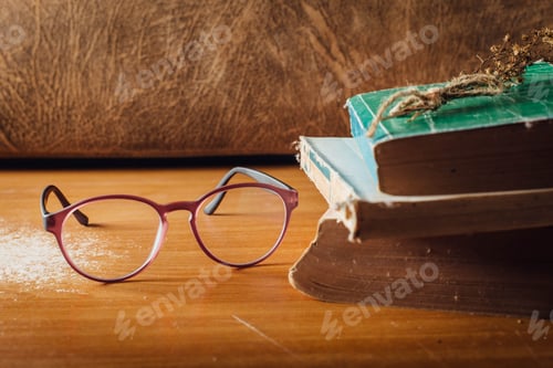 Preview: Vintage Eyeglasses with Books on Table
