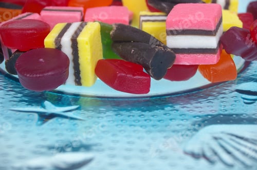 Preview: Soft Colored Jelly Lollies And Licorice On Blue Glass Plate