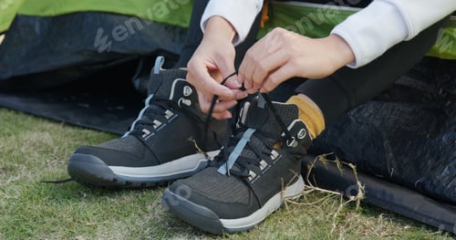 Preview: Woman Tying Her Shoes After Hiking At Camping Site