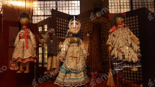 Preview: Antique Wooden Dolls Behind A Glass Case For Display