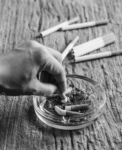 Preview: Crumpled Cigarette In Hand With Ashtray On Wooden Table,Quit Smoking,Monochrome Filter