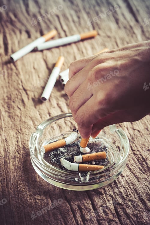 Preview: Crumpled Cigarette In Hand With Ashtray On Wooden Table,Quit Smoking