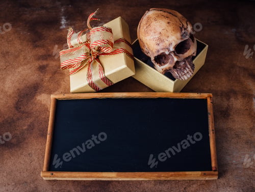 Preview: Model Skull In The Gift Box With Blackboard On Old Wooden Floor