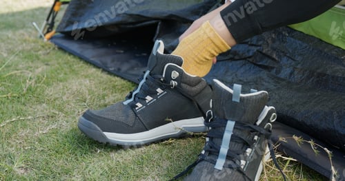 Preview: Woman Tying Her Shoes After Hiking At Camping Site