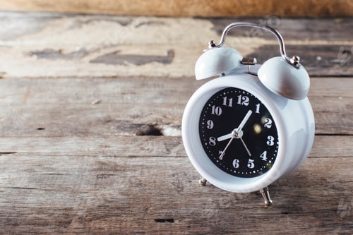 Preview: White Alarm Clock On Wooden Table