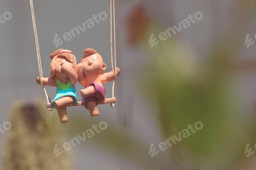 Preview: Happy Clay Dolls Sitting On Swing.
