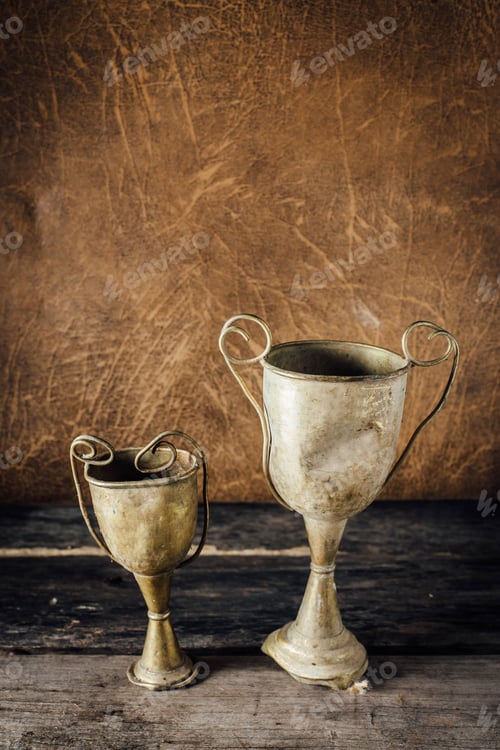 Preview: Still Life Of Old Trophies On Wooden Table With Leather Background