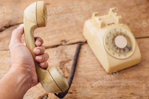 Preview: Old Telephone On Hand,On Wooden Table