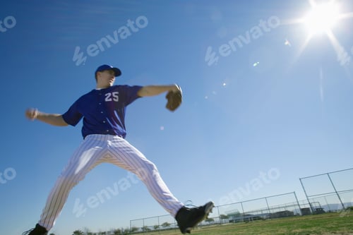Preview: Baseball Pitcher, In Blue Uniform, Preparing To Throw Ball During Competitive Game, Side View (Lens