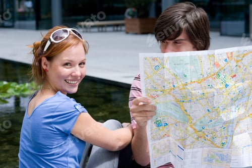 Preview: Portrait Of Young Tourist Couple On Vacation Looking At Map