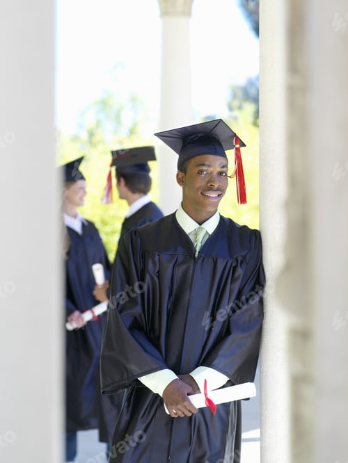 Preview: Young Man Graduating In Cap And Gown Holding Diploma