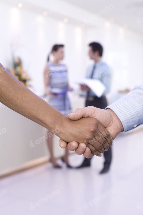 Preview: Businessman And Woman Shaking Hands, Colleagues In Background, Close-Up Of Hands