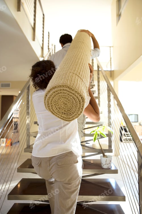 Preview: Couple Moving In Carrying Rug Upstairs Into New Home