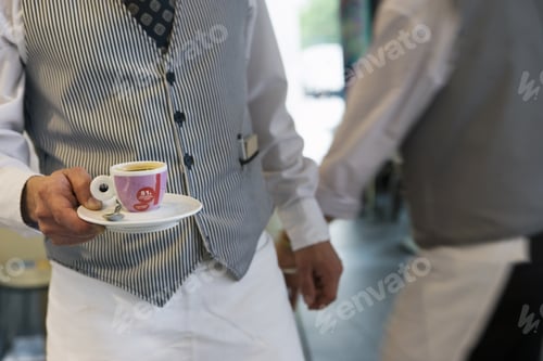 Preview: Two Waiters Working In Cafe, Man Carrying Expresso Cup And Saucer, Mid-Section, Focus On Foreground