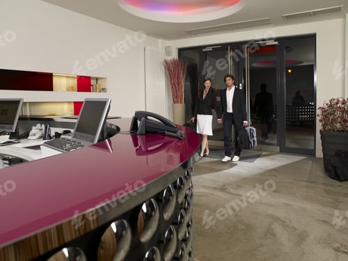 Preview: Couple Checking In At A Hotel Reception.