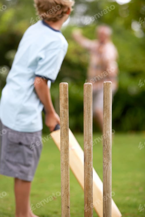 Preview: Grandfather And Grandson Playing Cricket With Man Bowling Boy Batting Viewed From Behind Cricket
