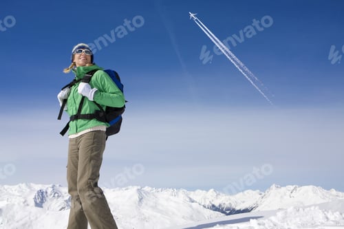 Preview: Airplane Flying Over Woman Backpacking On Snowy Mountain