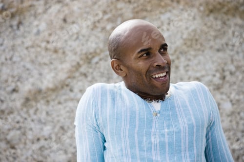 Preview: Man In Blue Top Sitting Beside Rock, Smiling, Close-Up