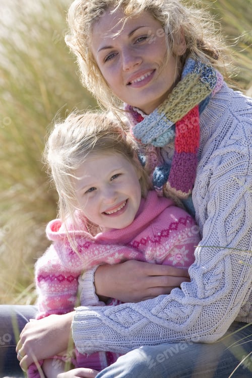 Preview: Portrait Of Mother Sitting With Daughter On Beach