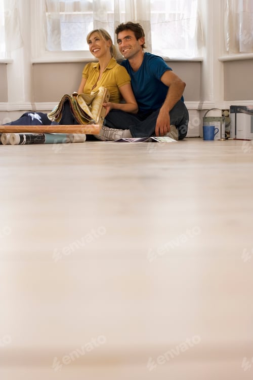 Preview: Couple Choosing Decorations And Furnishings For New Home Room Sitting On Floor Beside Window With
