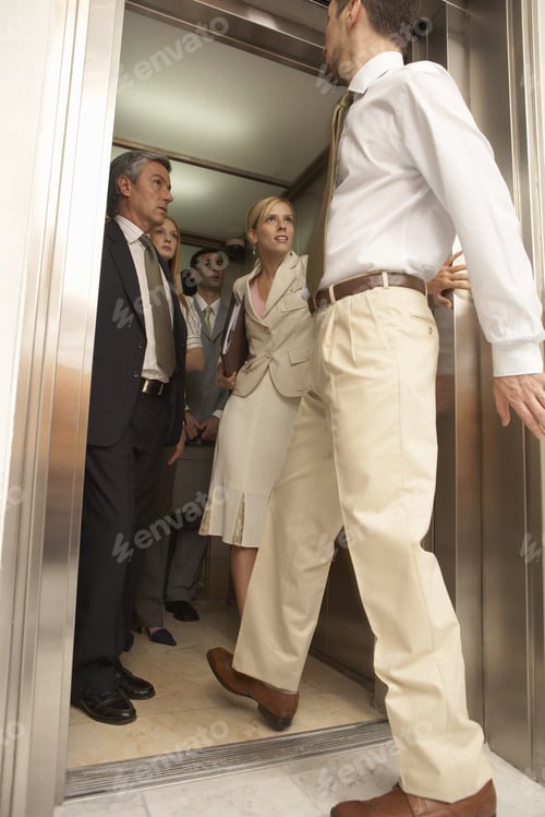 Preview: Side View Of A Businessman Entering An Elevator With Four Business Executives In It