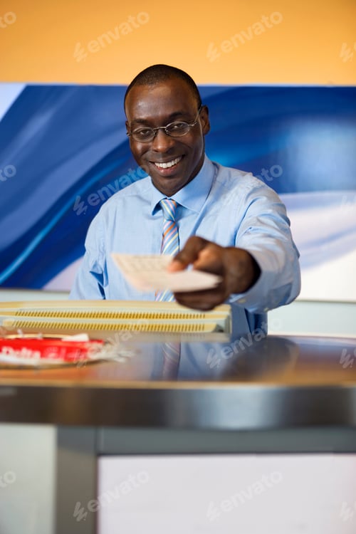 Preview: Male Attendant Passing Passenger Ticket At Airport Check-In Counter