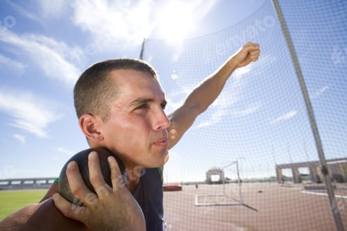 Preview: Male Athlete Preparing To Throw Shot Put Ball, Low Angle View (Lens Flare)