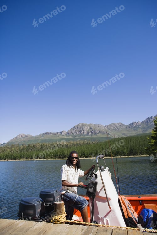 Preview: Man Standing At Helm Of Moored Motorboat Beside Lake Jetty, Smiling, Side View, Portrait
