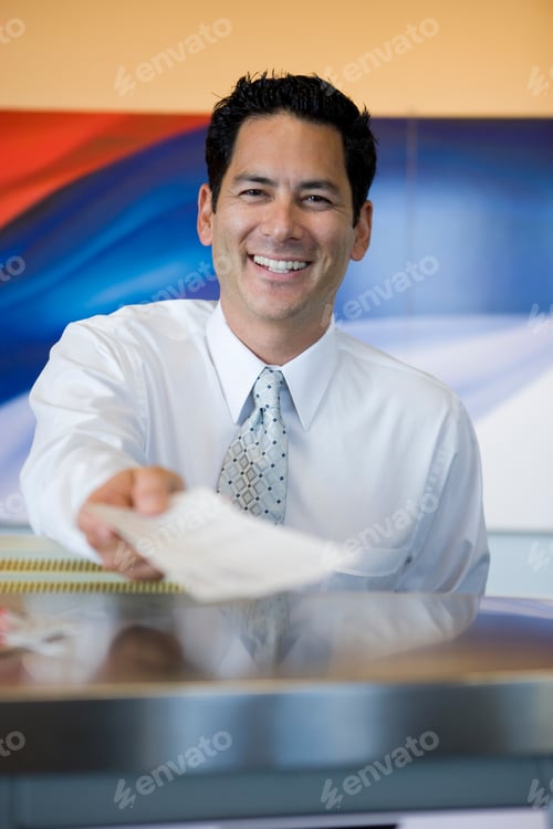 Preview: Man Working At Airport Check In Desk Handing Over Ticket