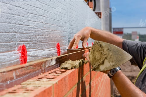 Preview: Close Up Of Bricklayer Laying Brick Wall On Construction Site