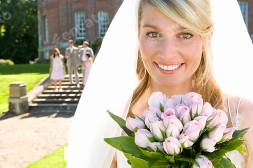 Preview: Beautiful Bride Holding Up Bouquet Of Flowers On Wedding Day At Camera