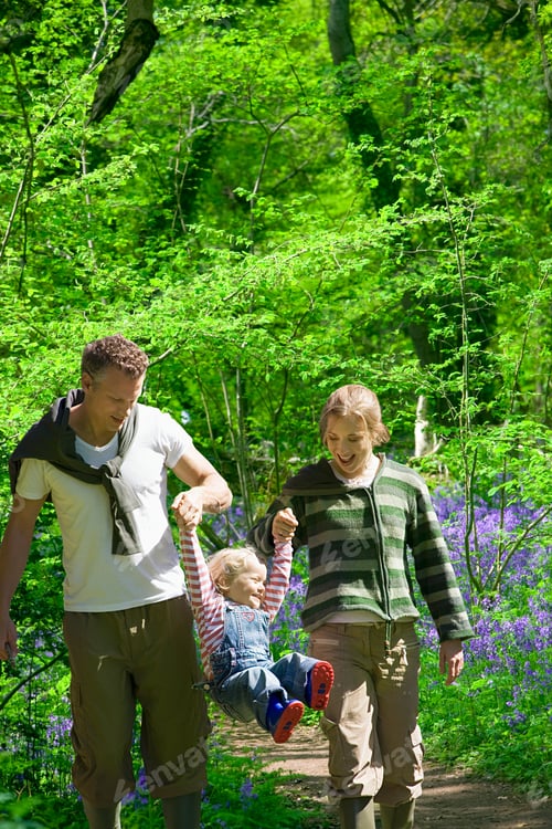 Preview: Couple Swinging Child In Forest Walking Through Spring Bluebells