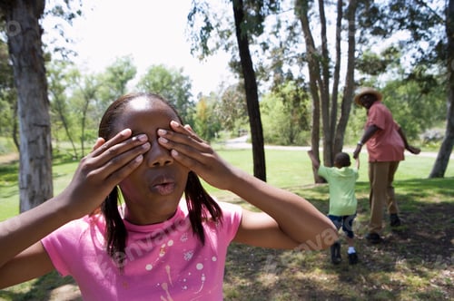 Preview: Hide And Seek In Summer Countryside With Grandchildren Covering Eyes And Grandfather Playing Along
