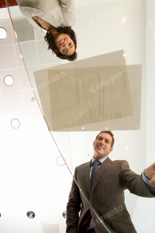 Preview: Business Colleagues In Office Looking At Contract Through Glass Table
