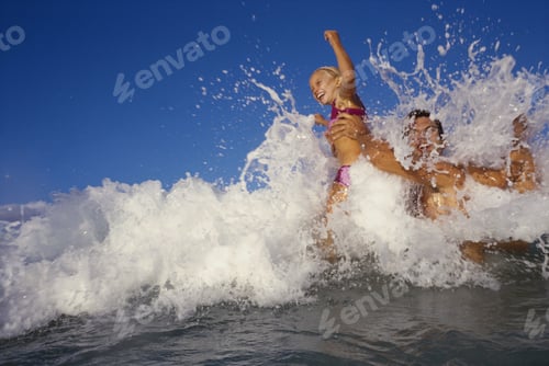 Preview: Mid Adult Man And His Daughter Splashing Water In The Sea