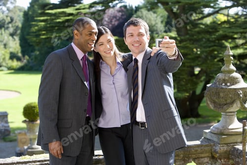 Preview: Young Businessman With Colleagues Taking Photograph Of Themselves Outdoors, Smiling