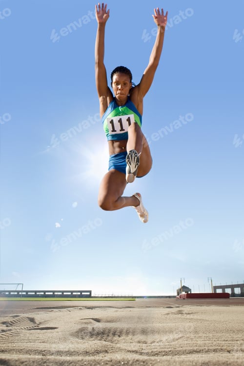 Preview: Mid-Air Shot Of Female Long Jumper Competing In Stadium Event
