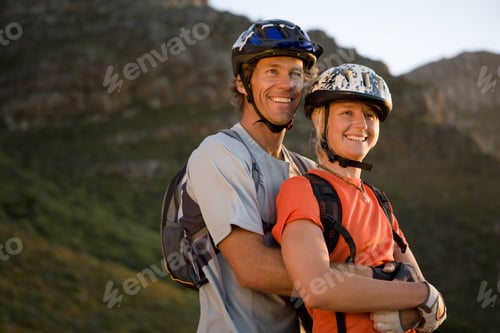 Vista previa: Pareja joven en bicicleta de montaña en la naturaleza, hombre abrazando a una mujer, vista de ángulo bajo