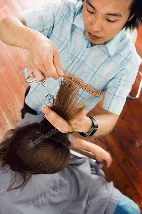 Preview: Fashionable Young Male Hairdresser Cutting Woman'S Hair In Salon Viewed From High Angle