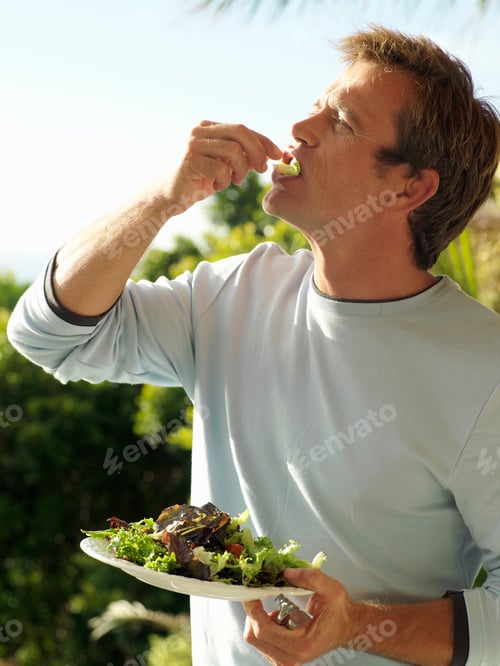 Preview: Man Eating Fresh And Healthy Salad Outdoors On Verandah