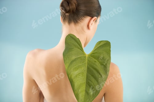 Preview: A Young Woman Holding A Tropical Leaf