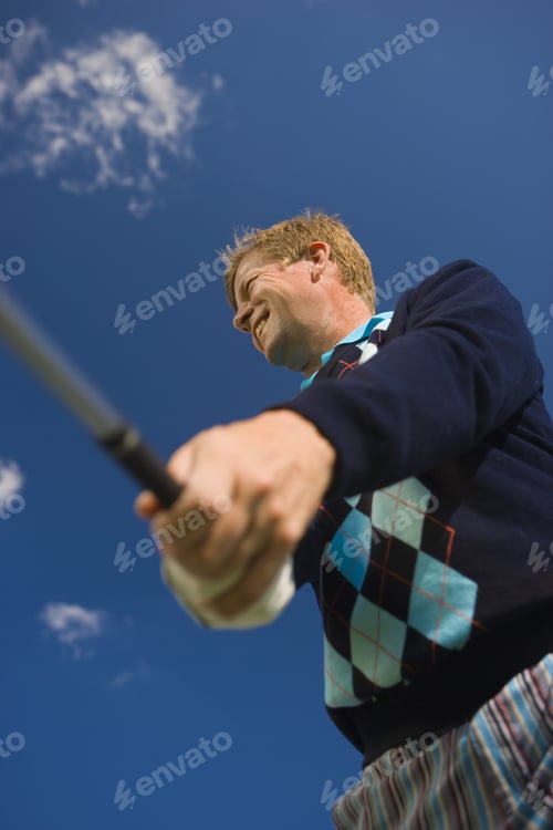 Preview: Low Angle View Of A Mid Adult Man Swinging A Golf Club And Smiling