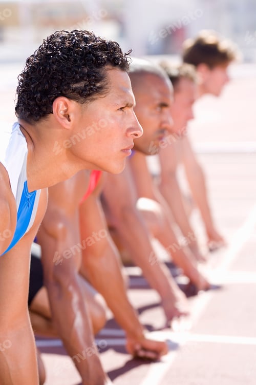 Preview: Competitive Male Athletes In Starting Blocks For Sprint Running Race