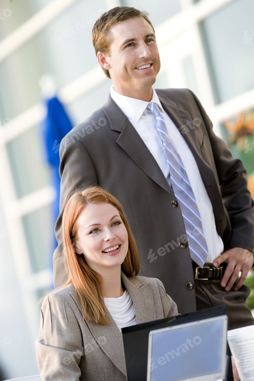 Preview: Businesswoman And Businessman Working At Pavement Cafe Table, Smiling (Tilt)