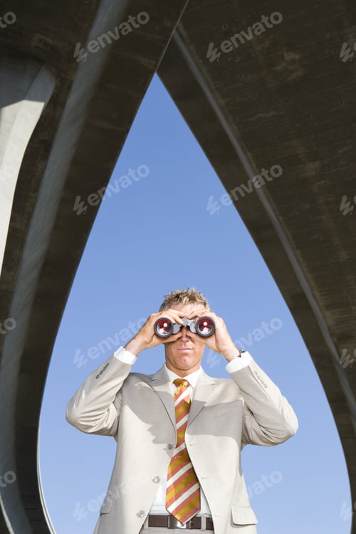 Preview: Businessman Using Binoculars Beneath Overpasses, Low Angle View